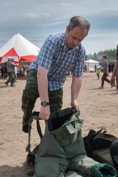 Man - visitor of show tries on the sapper suit
