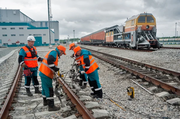 Railway workers repairing rail in rain