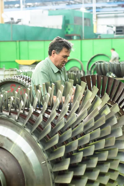 Mechanic works with part of aviation engine