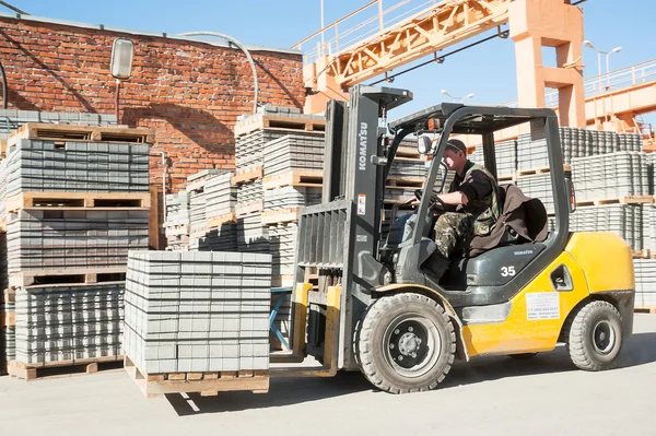 Driver on lift truck loads products of plant