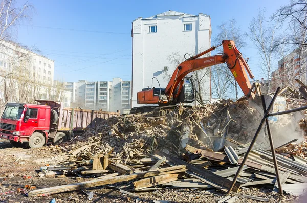 Excavator loads garbage from demolished house