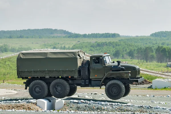 Army truck URAL-4320 jumps through obstacle
