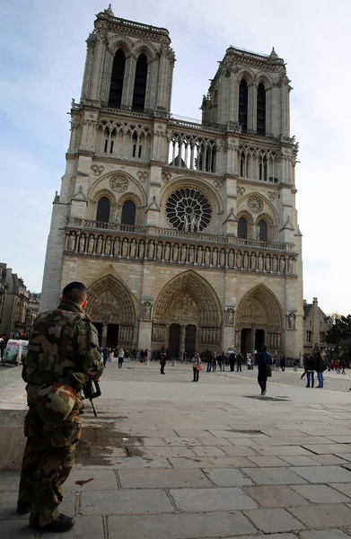 French soldier in uniform is near Notre Dame de Paris