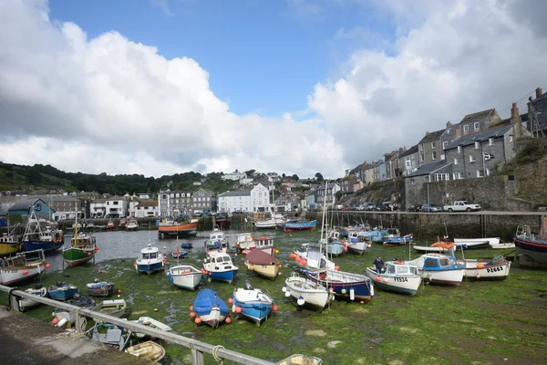 Harbour of small Cornish fishing village with fishing boats