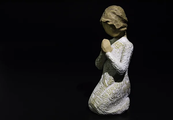 Sculpture prayer doll isolated on black background