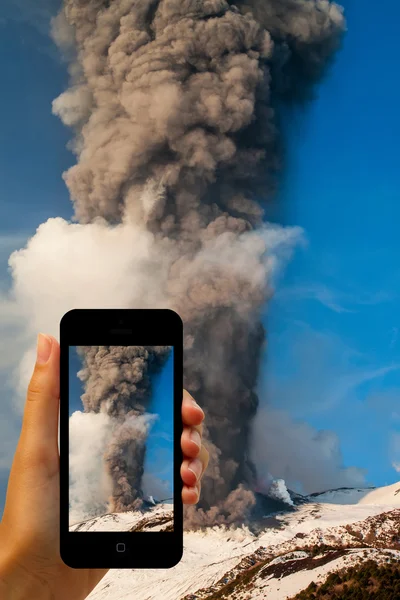 Tourist photographing the volcano eruption on smartphones