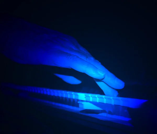 Tickling The Ivories - Hand Playing Piano Under Blue Spotlight