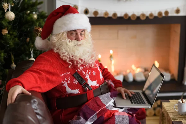 Santa Reading children\'s letters on laptop
