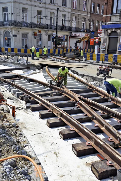 Some workers repair and replace some rail trams