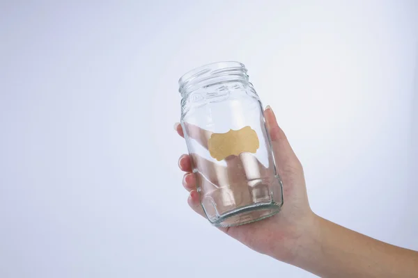 Female hand holding a empty jar
