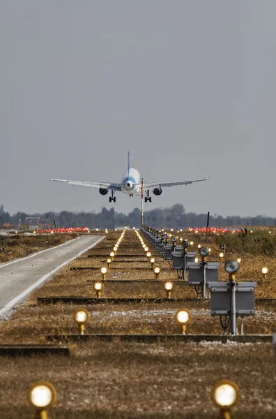 Italy, Venice International Airport, airport landing lights and an airplane landing in the background
