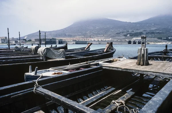 Italy, Sicily, Favignana Island, tuna fishing wooden boats in the port (the tuna fishing factory in the background) - FILM SCAN