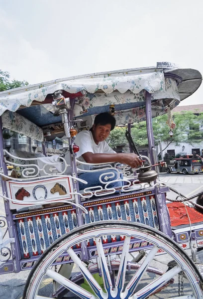 PHILIPPINES. Manila; 17 March 2000, man on a hand painted wooden wheel carriage - EDITORIAL (FILM SCAN)