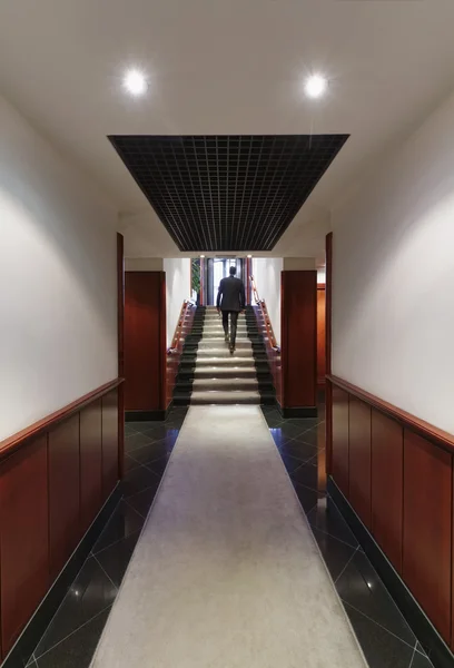 Businessman walking in a corporate building corridor