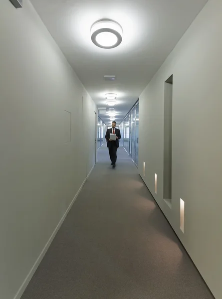 Man walking in a corporate building corridor