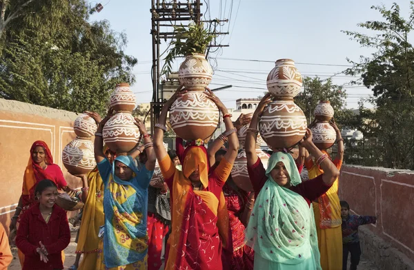 Indian women taking food to a wedding
