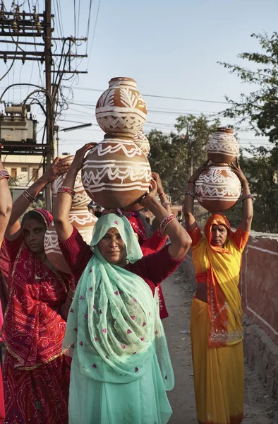 Indian women taking food to a wedding