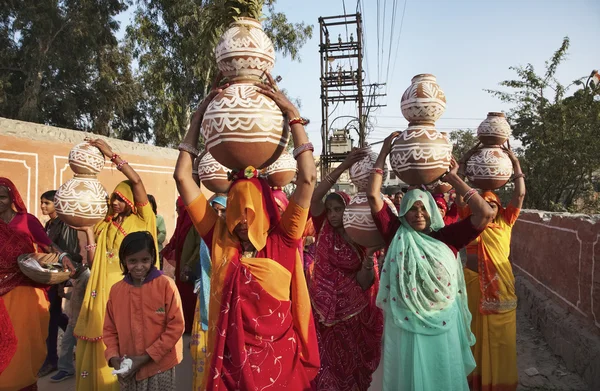 Indian women taking food to a wedding