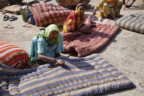 Indian women sewing mattresses in the street