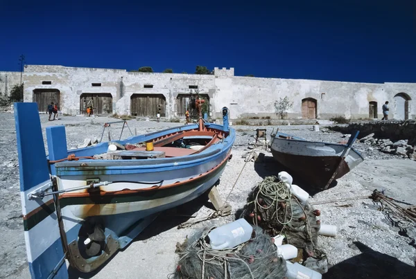 Italy, Sicily, S. Vito Lo Capo (Trapani Province), wooden fishing boats and the facade of the old Tuna Fishing factory - FILM SCAN