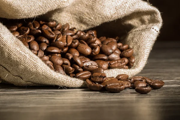 Closeup from a filled burlap bag with coffee beans.