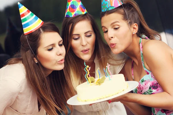 Friends blowing candles on cake