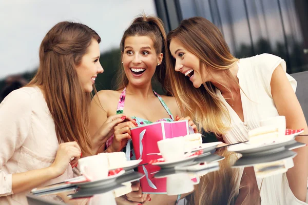 Friends chatting in cafe with shopping bag