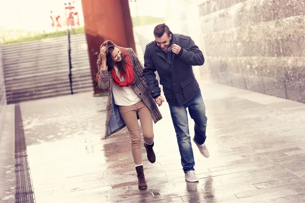 Couple running in the rain