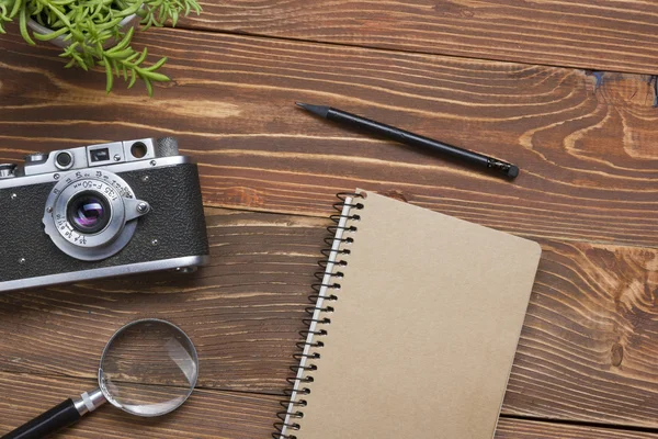 Travel, vacation concept. Camera and supplies on office wooden desk table. Top view with copy space for text