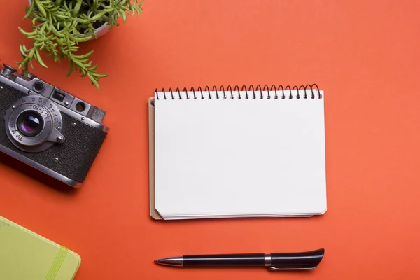 Tourism, travel concept. Office desk table with notepad, camera and supplies. Top view. Copy space for text.