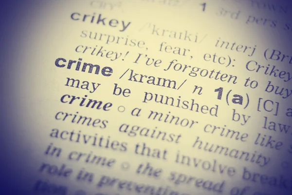 Dictionary definition of the word Crime in English. Vignetting effect.