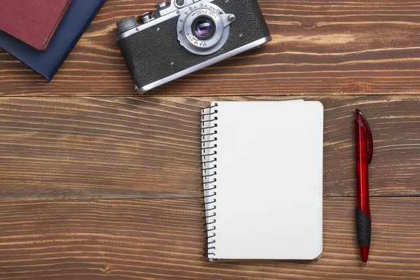 Travel, vacation concept. Camera and supplies on office wooden desk table. Top view with copy space for text