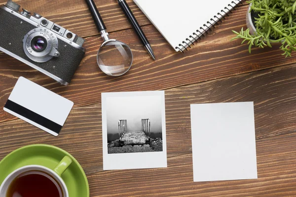 Travel, vacation concept. Camera, notepad, pen, credit card, supplies and photography on office wooden desk table. Top view with copy space for text