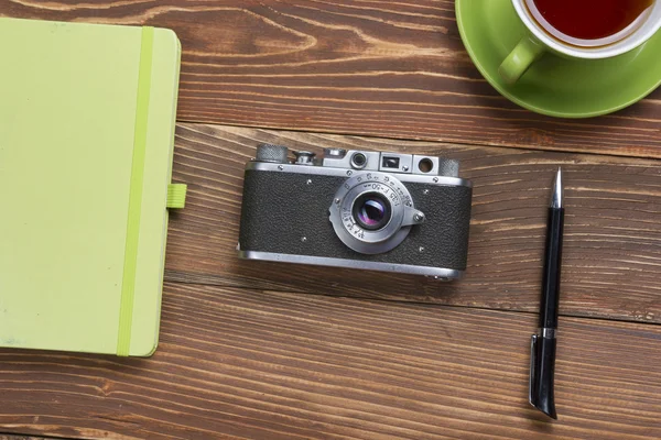 Travel, vacation concept. Camera and supplies on office wooden desk table. Top view with copy space for text