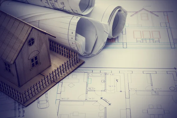 Real Estate concept. Architect workplace. Architectural project, blueprints, blueprint rolls and  model house on plans. Top view. Construction background. Engineering tools.