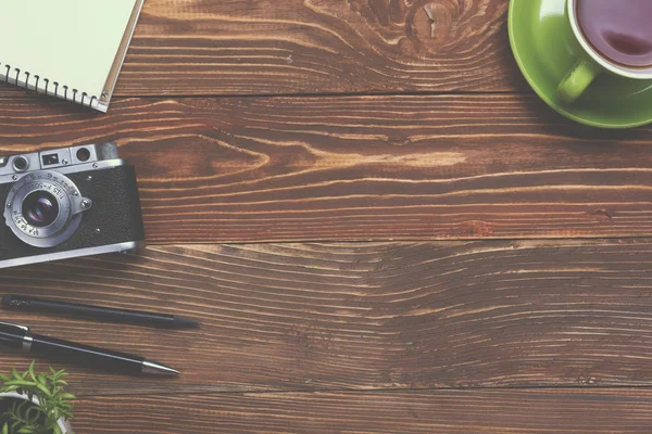 Travel, vacation concept. Camera and supplies on office wooden desk table. Top view with copy space for text