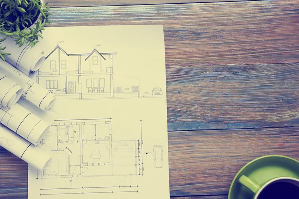 Architect worplace top view. Architectural project, blueprints, blueprint rolls and  divider compass, calipers on vintage wooden desk table. Construction background. Engineering tools. Copy space