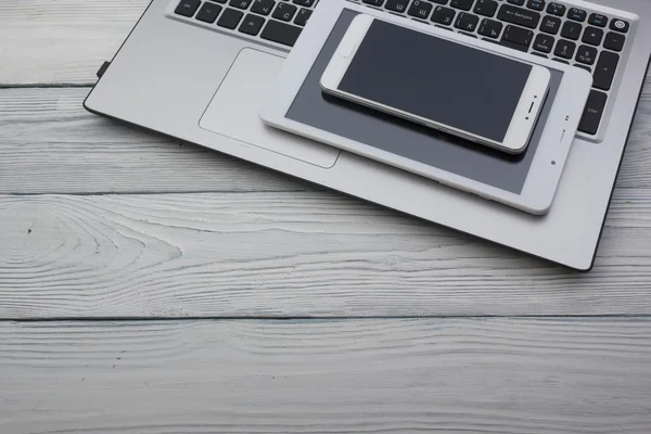 Set of modern computer devices - laptop, tablet and phone close up