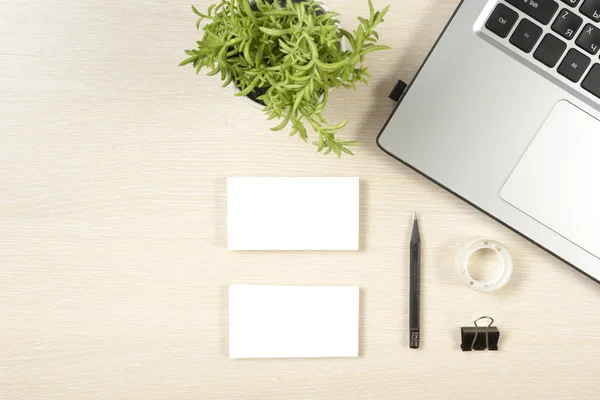 Business card blank, laptop, flower and pencil at office desk table top view. Corporate stationery branding mock-up