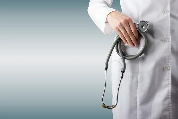 Female doctor\'s hand holding stethoscope on blurred background. Concept of Healthcare And Medicine. Copy space.