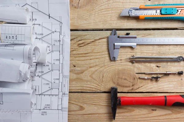 Architectural project, blueprints, blueprint rolls and divider compass, calipers on vintage wooden background. Construction concept. Engineering tools. Copy space