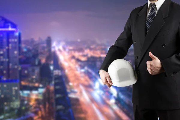 Close up of engineer hand holding white safety helmet for worker