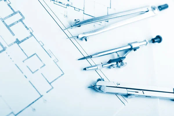 Architectural project, blueprints, blueprint rolls and divider compass, calipers, folding ruler on plans Engineering tools view from the top. Copy space. Construction background. Blue toned