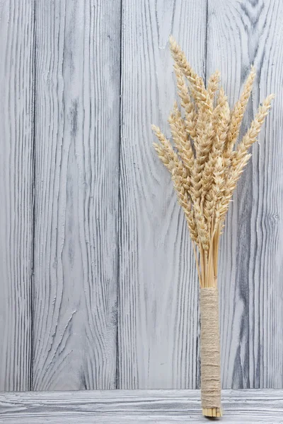 Wheat Ears on Wooden Table. Sheaf of Wheat over Wood Background. Harvest concept.