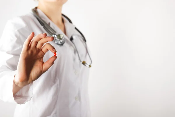 Female doctors hand giving pills. Close up shot on grey blurred