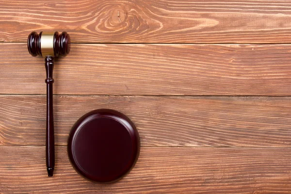 Law book with wooden judges gavel on table in a courtroom or law enforcement office.