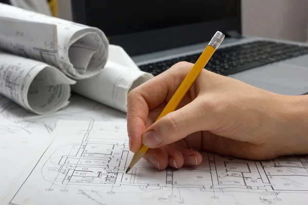 Architect working on blueprint. Architects workplace - architectural project, blueprints, ruler, calculator, laptop and divider compass. Construction concept. Engineering tools