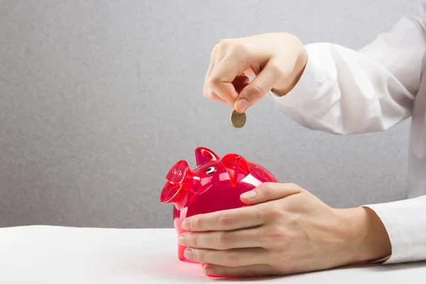 Savings Woman Putting Coin In Piggy Bank. Savings, finances, economy and home concept