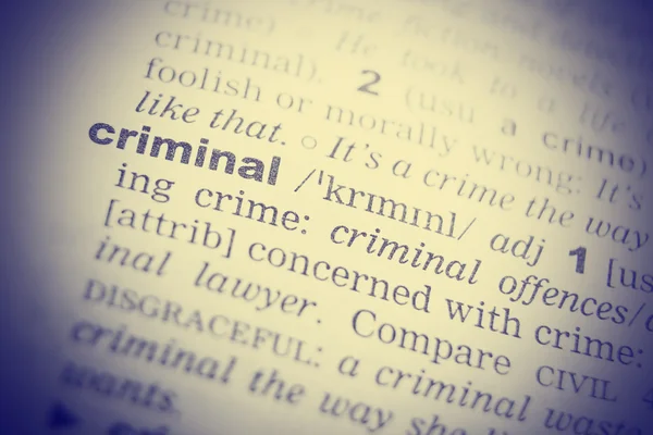 Dictionary definition of the word Criminal in English. Vignetting effect.
