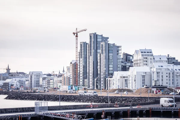 Reykjavik city with tall buildings and a crane at a construction